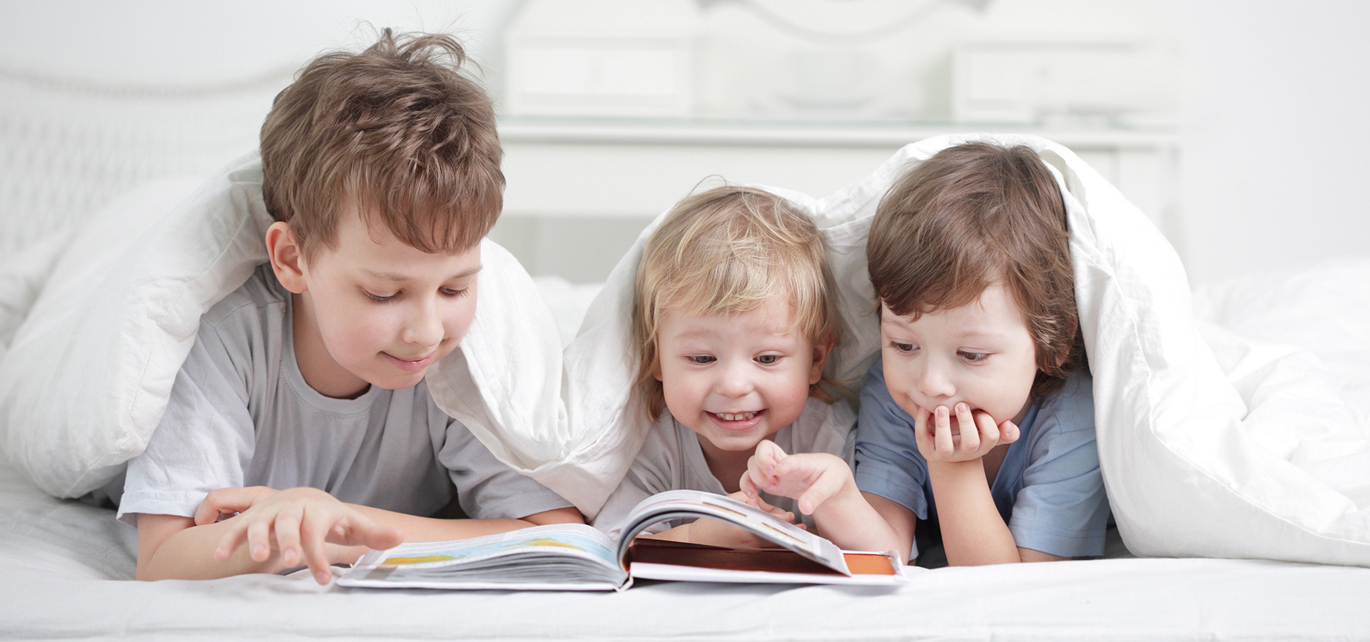 children reading under a duvet
