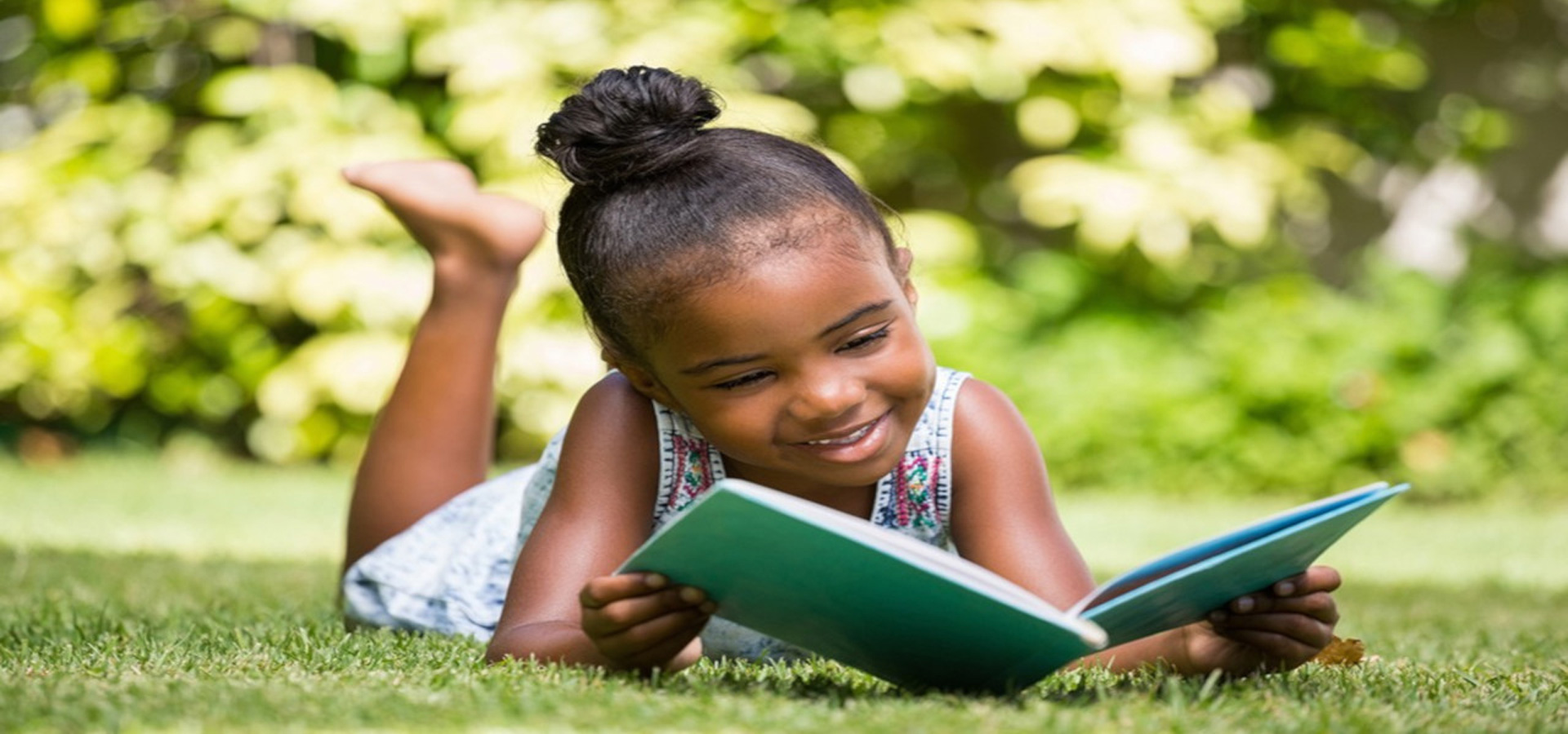 young girl enjoying a book outside