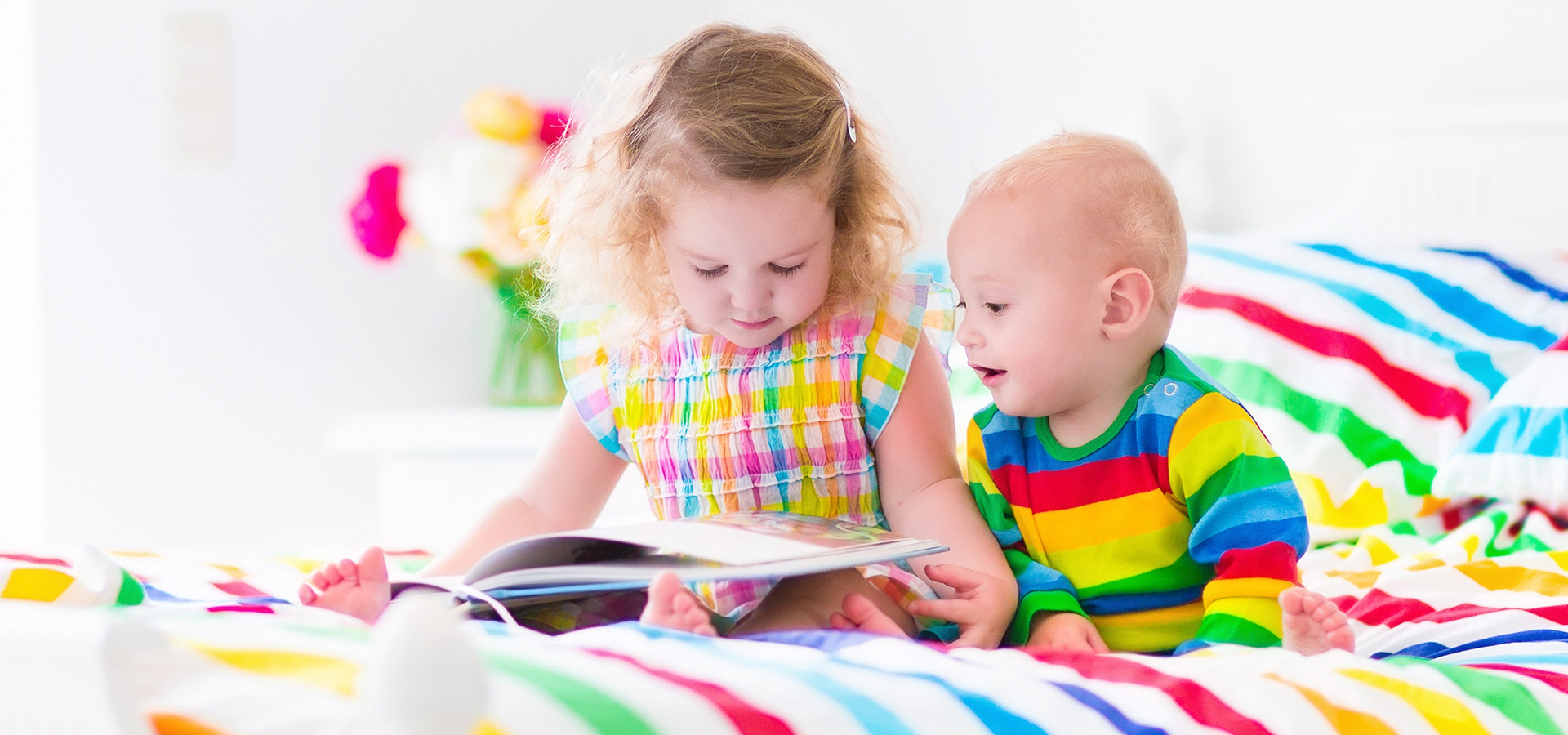 young girl reading to her baby brother